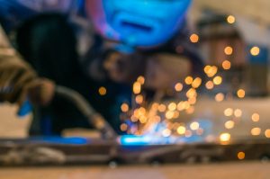 Heavy Industry Welder Worker In Protective Mask Hand Holding Arc